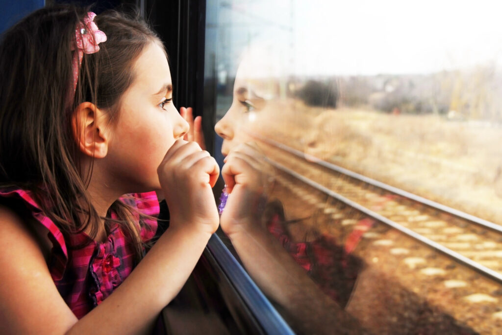 A young girl looking out of a train window