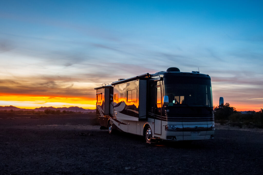 A beautiful sunset behind a large modern RV